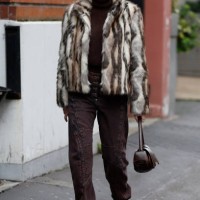 Guest wears brown turtleneck sweater, brown jeans, beige and brown fur jacket, brown bag, outside Kiko Kostadinov, during the Menswear Fall Winter...