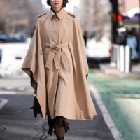 Guest wears dark brow belted trench cape, dark brown midi skirt, dark brown tights, shiny black pointed toe heel leather shoes, shiny black leather...
