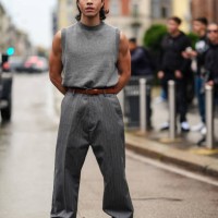 Guest wears dark gray sweater vest, dark brown leather belt, dark gray lined baggy loose pants, shiny black platform boots, outside Onitsuka Tiger,...