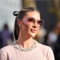 Guest wears dark pink sunglasses, black hair bow, light pink silver embellished short sleeve shirt, outside Valentino, during the Paris Fashion week...
