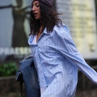 Guest wears dark red gray pattern hat, navy blue denim jean coat I'm hand, light blue white lined buttoned up long sleeve oversized shirt, bright...