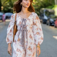 Guest wears dress with print, brown bag, sandals outside Bora Aksu during London Fashion Week September 2023 on September 15, 2023 in London, England.