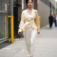Guest wears earrings, a white lustrous dress with mesh / lace and floral embroidery, a pale pastel yellow silk lustrous cardigan, pointed shoes,...