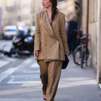 Guest wears gold earrings, dark orange light gray pattern/print linen wrapped oversized The Row Jeremiah blazer jacket, dark orange light gray...