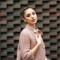 Guest wears gold earrings, light pink buttoned sweater blazer jacket, outside N21, during the Milan Fashion week Men’s Fall/Winter 2025-2026 on...