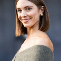 Guest wears gold hoop earrings and a dove grey knitted sweater outside Philosophy show during the Milan Fashion Week Menswear Spring/Summer 2025 on...