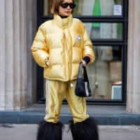 Guest wears golden puffer jacket, jogger pants, faux fur black boots outside Palm Angels Paris Fashion Week - Womenswear Fall Winter 2023 2024 : Day...
