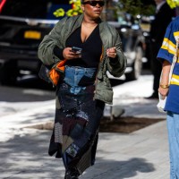 Guest wears green bomber jacket, vinyl skirt outside Toteme during New York Fashion Week on September 10, 2024 in New York City.