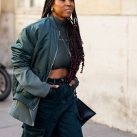 Guest wears green cropped top, bomber jackt, pants with side pockets outside Sacai during the Womenswear Fall/Winter 2024/2025 as part of Paris...