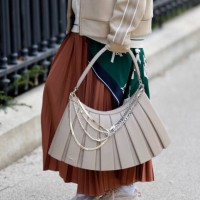 Guest wears green Lacoste printed long top, cream cardigan, beige Lacoste jacket, brown pleated maxi skirt, beige Lacoste bag, beige Lacoste...