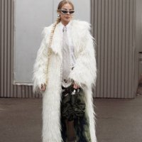 Guest wears green pants, a white shirt, a grey tie with cut out heart, and an army green bag outside Vain during the Copenhagen Fashion Week AW24 on...