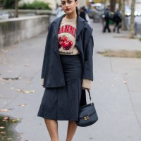Guest wears grey blazer, skirt, black bag outside Ganni during Womenswear Spring/Summer 2025 as part of Paris Fashion Week on September 24, 2024 in...