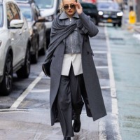 Guest wears grey coat, zipper, pants outside Michael Kors on February 13, 2024 in New York City.