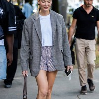 Guest wears grey oversized blazer, striped shorts, white shirt outside Issey Miyake during the Menswear Spring/Summer 2026 shows as part of Paris...