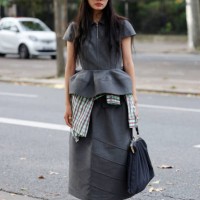 Guest wears grey peplum top with matching long skirt, blue New Era hat, blue bag, brown decorated sneaker, outside Rokh, during Womenswear...