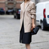 Guest wears grey socks, silver sparkly pumps, grey sunglasses, a beige blazer, a grey long skirt and a black lather bag outside Sportmax show during...