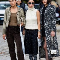 Guest wears jacket, brown pants & Sophia Roe wears sleeveless creme white turtleneck knit, skirt with print, boots & a guest wears grey white black...