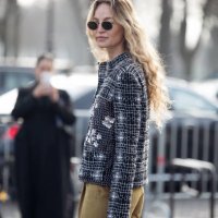 Guest wears khaki pants and white and black tweed jacket outside the Chanel fashion show during the Womenswear Fall/WinterV 2025/2026 as part of...