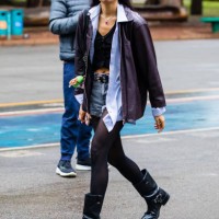 Guest wears leather jacket, black top, light blue button-up shirt underneath, denim shorts, black tights, black biker boots, belt with silver details...