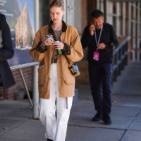 Guest wears light brown oversized jacket, light gray sweater, dark brown leather belt, white denim jean cuffed pants, black light brown leather...