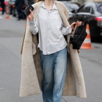 Guest wears light grey striped shirt, brown suede coat with fur inside, light wash jeans, black Chanel bag, outside Chanel, during the Womenswear...