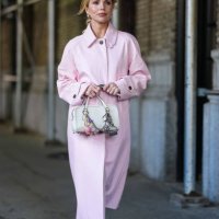 Guest wears light pink Coach leather wind coat, white leather bag, bag charms, white tights, white mary jane heels, outside Coach, during the New...