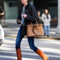 Guest wears light yellow sunglasses, light gray sweater, dark navy blue oversized jacket, light brown caramel belted Prada leather bag, navy blue...