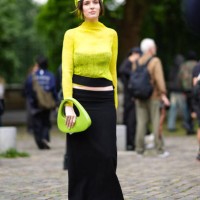 Guest wears lime bright green beret, lime bright green sheer mesh long sleeve top, strapless black top, lime green bag, low-waisted black maxi skirt,...