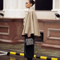Guest wears long black skirt, beige trench coat, white shoes and Dior bag during the 10th season of the Visa Fashion Week Almaty on October 16, 2024...