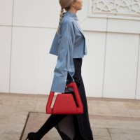 Guest wears long denim maxi skirt with a split, light blue shirt and red bag during the Tashkent Fashion Week 2023 on November 28, 2023 in Tashkent,...