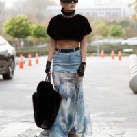 Guest wears long skirt part blue denim, part white and blue silk with a black belt, black leather gloves from Dolce & Gabbana, black big fur bag,...