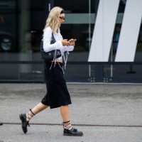 Guest wears navy blazer, Miu Miu bag, knee high socks outside Lueder during the Berlin Fashion Week SS25 on July 01, 2024 in Berlin, Germany.