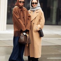 Guest wears navy blue wide pants, brown short coat with tassels and brown head scarf and a guest wears long beige coat, balck bag and grey balaclava...