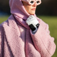 Guest wears pink coat, scarf, jumper, sunglasses, Chanel gloves outside Marimekko during the Copenhagen Fashion Week AW24 on February 01, 2024 in...