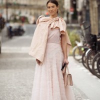 Guest wears pink tule maxi dress, beige bag and pale pink shirt outside the Akris fashion show during the Womenswear Fall/Winter 2025/2026 as part of...