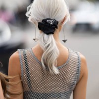 Guest wears Prada pendant earrings, a Prada black hairband, a black bra and a rhinestones fishnet silver tank top outside Prada show during the Milan...