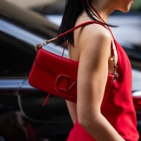 Guest wears red bag, dress outside Valentino during the Womenswear Fall/Winter 2024/2025 as part of Paris Fashion Week on March 03, 2024 in Paris,...