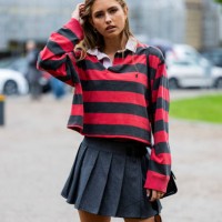 Guest wears red black striped polo with long sleeves, grey pleated mini skirt outside OpéraSport during the Copenhagen Fashion Week Spring/Summer...