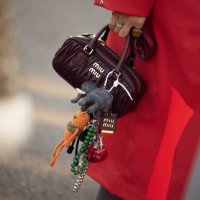 Guest wears red coat and brown Miu Miu bag with accessories during the 10th season of the Visa Fashion Week Almaty on October 18, 2024 in Almaty,...