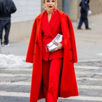 Guest wears red coat, blazer, pants, silver bag outside Michael Kors during New York Fashion Week on February 11, 2025 in New York City.