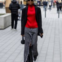 Guest wears red turtleneck, black blazer, grey denim jeans skirt with slit outside Mark Fast during London Fashion Week February 2024 on February 16,...