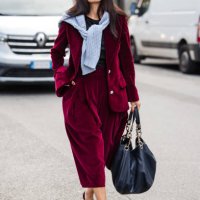 Guest wears red velvet blazer with matching midi skirt, burgundy heels, blue big bag, outside Max Mara, during the Milan Fashion Week Spring/Summer...