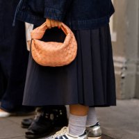 Guest wears salmon colored Bottega Veneta bag, silver Adidas sneaker outside Bora Aksu during London Fashion Week September 2024 on September 13,...
