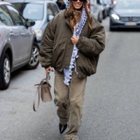 Guest wears scarf, bomber jacket, beige pants, Hermes bag outside Lovechild 1979 during the Copenhagen Fashion Week AW24 on January 30, 2024 in...