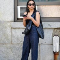 Guest wears sunglasses, a black tank top, blue denim jeans pants, a black leather bag, golden earrings, holds a mobile phone, outside Gabriela...