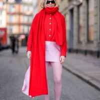 Guest wears sunglasses, a red oversized long scarf, a red cardigan, a pink mini skirt, tights, red and pink sneakers shoes , outside Mark Kenly...