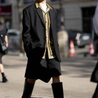 Guest wears sunglasses, a yellow shirt with printed patterns, a black oversized blazer jacket, outside Stella McCartney, during the Womenswear...