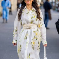 Guest wears white belted dress with floral print, white bag outside Zimmermann during the Womenswear Fall/Winter 2024/2025 as part of Paris Fashion...