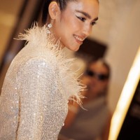 Guest wears white sequin pants, and cropped top with white feathers and a white mini bag during the Tashkent Fashion Week 2023 on November 27, 2023...