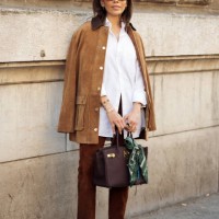 Guest wears white shirt, brown pants, brown suede jacket and brown Hermes bag with a green and white silk neck scarf outside the Hermes fashion show...